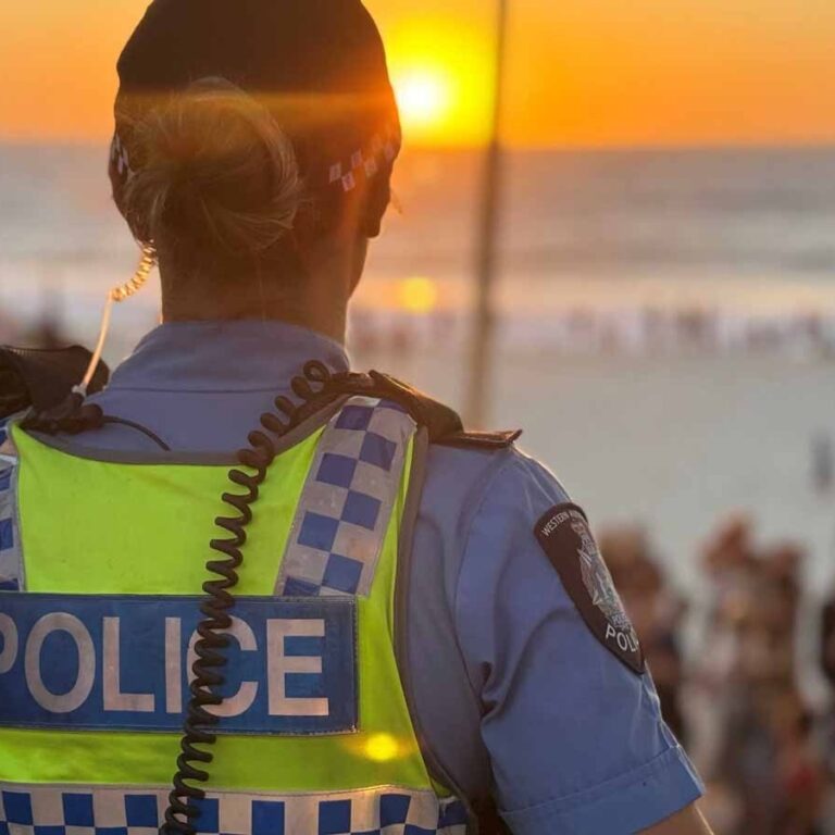 Female police officer looking out at a sunset.
