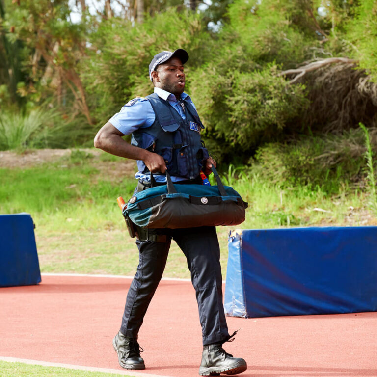 Police recruit walking with a heavy bag in training